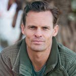 Close-up portrait of a man wearing a casual jacket outdoors.
